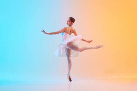 Photo for Young ballerina in white tutu doing arabesque in motion in neon light against blue-orange gradient background. Concept of art, movement, grace, classical and modern fusion, beauty and fashion. Ad - Royalty Free Image