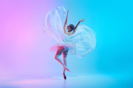 Téléchargez les photos : Portrait of young ballerina dancing standing on tiptoe with fabric in neon light against vivid gradient background. Concept of art, movement, classical and modern fusion, beauty and fashion. Ad - en image libre de droit