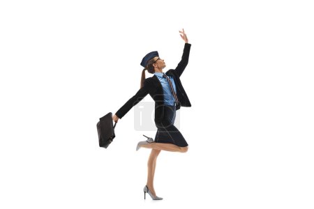 Photo for Elegant stewardess in business suit, balancing on foot, holding briefcase, showing grace and professionalism, isolated on white background. Concept of business, occupation, profession, success, growth - Royalty Free Image