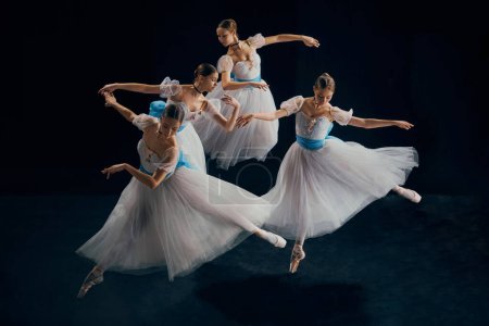 Téléchargez les photos : Image de jeunes danseuses de ballet en mouvement synchronisé, leur tutus blanc créant une harmonie fluide d'élégance floue. Concept de beauté, classique et modernité, art contemporain. Publicité - en image libre de droit