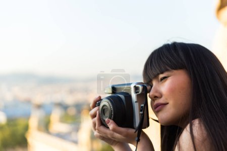 Téléchargez les photos : Jeune asiatique européenne femme faire vue voir et sourire alors qu'elle prend des photos avec un vieil appareil photo - en image libre de droit