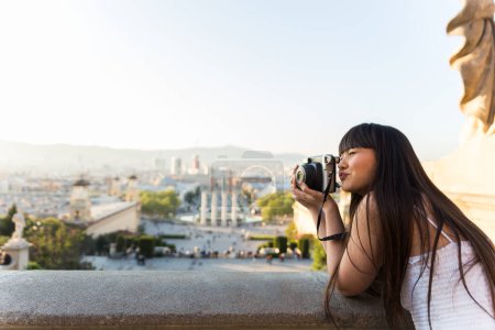Téléchargez les photos : Jeune asiatique européenne femme faire vue voir et sourire alors qu'elle prend des photos avec un vieil appareil photo - en image libre de droit