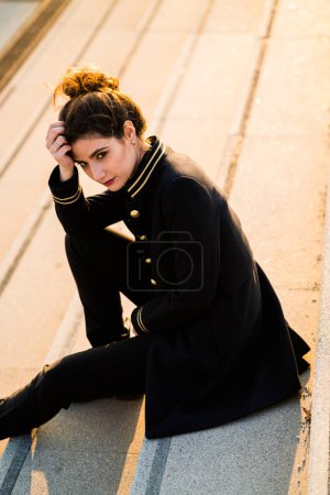 Téléchargez les photos : Jeune modèle adulte portant une veste noire et dorée regardant loin de la caméra. - en image libre de droit