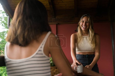 Téléchargez les photos : Jeune couple de filles prenant une tasse de café dans une terrasse. - en image libre de droit