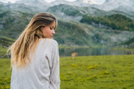 Téléchargez les photos : Femme en plein air profitant de la nature, avec un lac et des montagnes en arrière-plan. - en image libre de droit