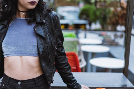 Téléchargez les photos : Jeune femme adulte portant une veste en cuir noir regardant loin de la caméra. - en image libre de droit