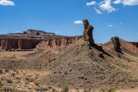 Photo for Stunning rock formations in Capital Reef National Park, Utah, USA. Lots of unique shapes made out of red, orange and grey stones. Desert vegetation in the foreground. Blue sky. - Royalty Free Image