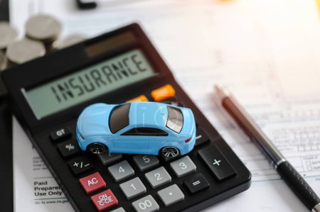 Blue car and calculator with document for protection of car in car insurance concept