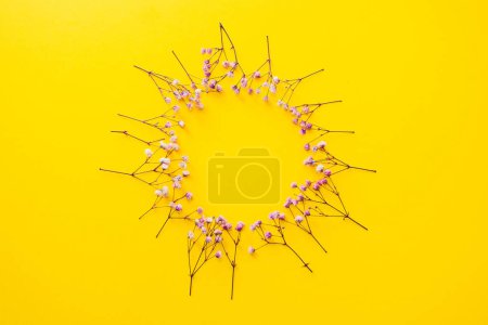 Photo for Purple flowers on a yellow background, arranged in a circle, form a frame, summer background - Royalty Free Image