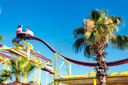 Foto de Diapositivas amarillas extremas con cabañas rojas en el fondo del cielo azul, clima tropical, parque de atracciones - Imagen libre de derechos