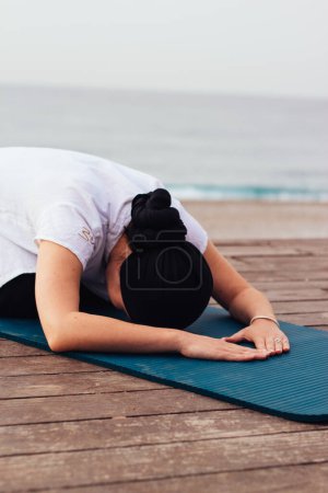 rest position in yoga, fitness, sport and healthy lifestyle concept - woman doing yoga exercise on the beach