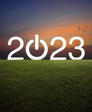 Téléchargez les photos : 2023 démarrer entreprise icône plate sur le champ d'herbe verte sur le coucher du soleil ciel avec des oiseaux, Bonne année 2023 concept - en image libre de droit