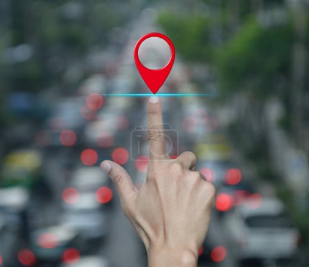 Photo for Hand pressing map pin point location button over blur of rush hour with cars and road in city, Map pointer navigation concept - Royalty Free Image