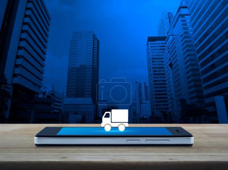 LKW-Lieferung flaches Symbol auf modernem Smartphone-Bildschirm auf Holztisch über Büroturm und Wolkenkratzer, Geschäftstransport Online-Konzept