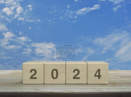 Photo for 2024 letter on wood block cubes on wooden table over blue sky with white clouds, Happy new year 2024 cover concept - Royalty Free Image