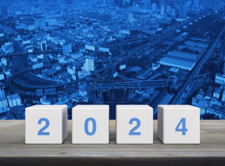 Photo for 2024 letter on white block cubes on wooden table over modern city tower, street, expressway and skyscraper, Happy new year 2024 cover concept - Royalty Free Image