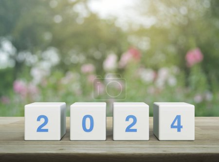 Photo for 2024 letter on white block cubes on wooden table over blur pink flower and tree in park, Happy new year 2024 cover concept - Royalty Free Image