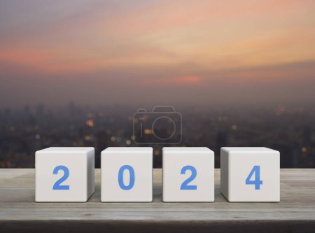 Photo for 2024 letter on white block cubes on wooden table over blur of cityscape on warm light sundown, Happy new year 2024 cover concept - Royalty Free Image