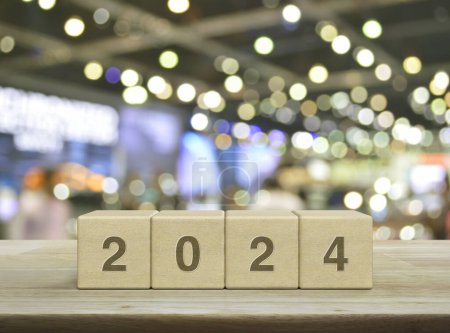 Photo for 2024 letter on wood block cubes on wooden table over blur light and shadow of shopping mall, Happy new year 2024 cover concept - Royalty Free Image