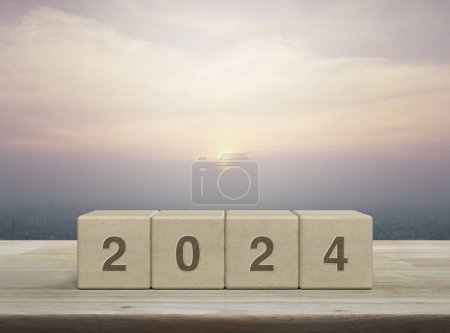 Photo for 2024 letter on wood block cubes on wooden table over city tower and skyscraper at sunset, vintage style, Happy new year 2024 cover concept - Royalty Free Image
