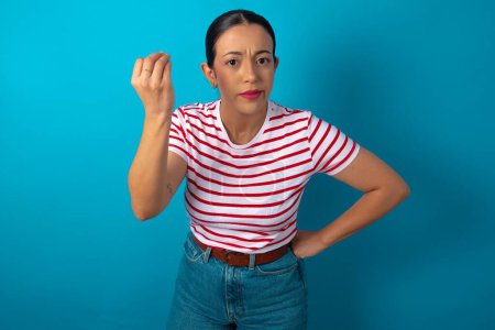 Foto de What the hell are you talking about. Shot of frustrated woman wearing striped T-shirt gesturing with raised hand doing Italian gesture, frowning, being displeased and confused with dumb question. - Imagen libre de derechos