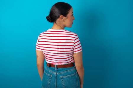 Photo for The back view of woman wearing striped T-shirt Studio Shoot. - Royalty Free Image