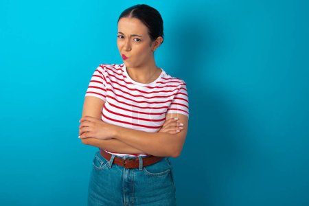 Photo for Picture of angry woman wearing striped T-shirt crossing arms. Looking at camera with disappointed expression. - Royalty Free Image
