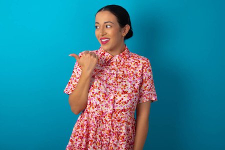 Foto de Mujer que usa puntos de vestido floral de distancia y da consejos demuestra publicidad - Imagen libre de derechos