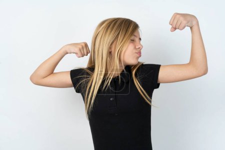Téléchargez les photos : Belle adolescente caucasienne portant un T-shirt noir sur un mur blanc montrant les muscles des bras souriant fier. Concept de fitness. - en image libre de droit