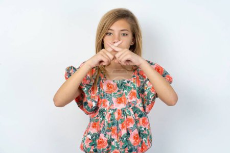 Photo for Beautiful caucasian teen girl wearing flowered blouse over white wall Has rejection angry expression crossing fingers doing negative sign. - Royalty Free Image