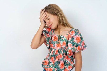 Photo for Displeased upset beautiful caucasian teen girl wearing flowered blouse over white wall frowns face as going to cry, being discontent and unhappy as can't achieve goals,  Disappointed model has troubles - Royalty Free Image