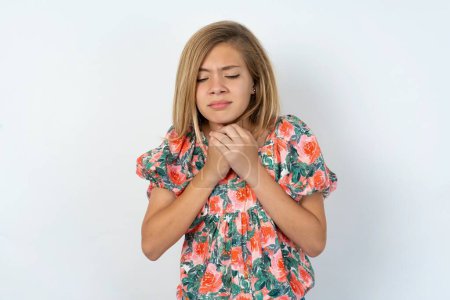 Photo for Doleful desperate crying beautiful caucasian teen girl wearing flowered blouse over white wall, looks stressfully, frowns face, feels lonely and anxious - Royalty Free Image