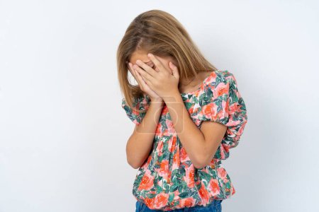 Photo for Sad caucasian teen girl wearing flowered blouse over white wall desperate and depressed with tears on her eyes suffering pain and depression  in sadness facial expression and emotion concept - Royalty Free Image