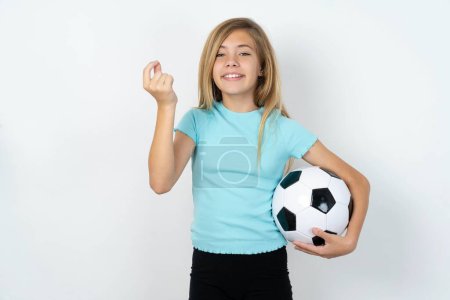 Photo for Caucasian teen girl wearing sportswear holding a football ball over white wall pointing up with hand showing up seven fingers gesture in Chinese sign language Q. - Royalty Free Image