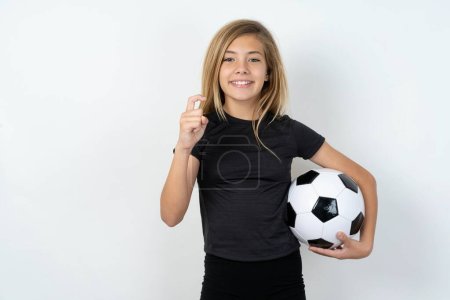 Foto de Chica rubia con bola usando ropa deportiva apuntando hacia arriba con los dedos número nueve en lengua de signos china Jiu - Imagen libre de derechos