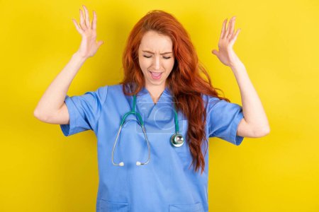 Photo for Young red-haired doctor woman over yellow studio background goes crazy as head goes around feels stressed because of horrible situation - Royalty Free Image