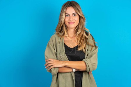 Photo for Self confident serious blonde woman wearing overshirt  stands with arms folded. Shows professional vibe stands in assertive pose. - Royalty Free Image