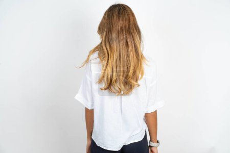 Photo for Back view of young caucasian businesswoman wearing white shirt over white background. Studio Shoot. - Royalty Free Image