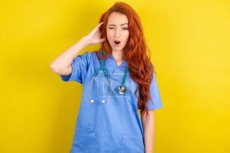 Photo for Young red-haired doctor woman yawns with opened mouth stands. Daily morning routine - Royalty Free Image