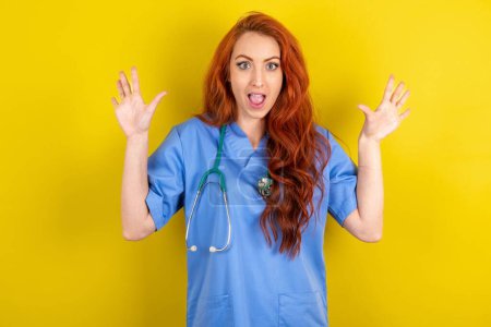 Photo for Delighted positive young red-haired doctor woman opens mouth  and arms palms up after having great result - Royalty Free Image