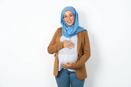 Foto de De cerca la foto de la mujer musulmana embarazada usando hijab toothy sonriendo - Imagen libre de derechos