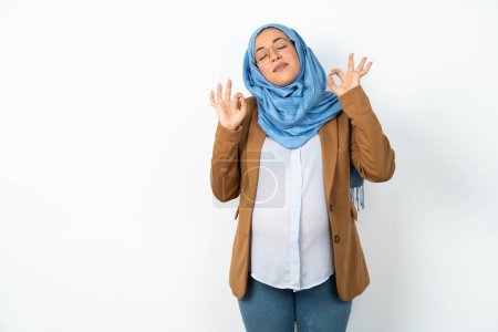 Téléchargez les photos : Femme enceinte musulmane portant hijab se détendre et sourire les yeux fermés en faisant geste de méditation avec les doigts. Concept de yoga. - en image libre de droit