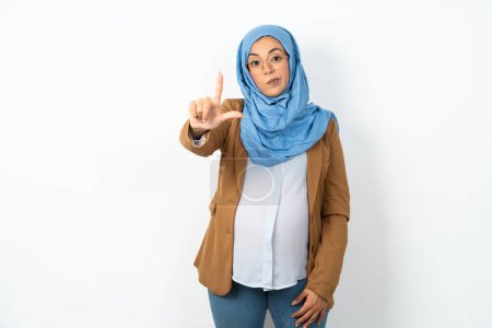 Téléchargez les photos : Femme musulmane enceinte portant hijab se moquant des gens avec les doigts sur le front faisant geste perdant moquerie et insultant. - en image libre de droit