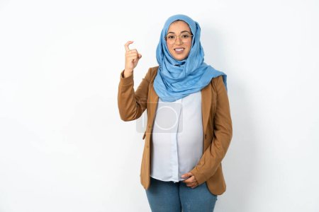 Photo for Pregnant muslim woman wearing hijab showing up number six Liu with fingers gesture in sign Chinese language - Royalty Free Image