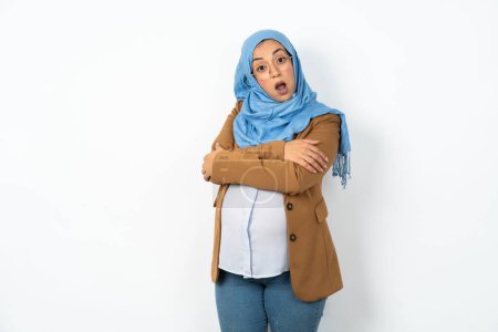 Photo for Shocked embarrassed pregnant muslim woman wearing hijab keeps mouth widely opened. Hears unbelievable novelty stares in stupor - Royalty Free Image