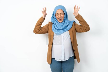 Photo for Beautiful pregnant muslim woman wearing hijab goes crazy as head goes around feels stressed because of horrible situation - Royalty Free Image