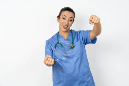 Foto de Árabe médico mujer vistiendo azul uniforme imaginar volante timón timón pasando examen de conducción buen humor velocidad rápida - Imagen libre de derechos
