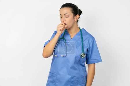 Téléchargez les photos : Médecin arabe femme portant un uniforme bleu se sentant mal et toussant comme symptôme du rhume ou de la bronchite. Concept de soins de santé. - en image libre de droit