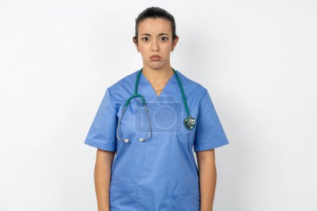 Téléchargez les photos : Offensé insatisfait femme arabe médecin en uniforme avec stéthoscope avec expression de mécontentement lunatique à la caméra être déçu par quelque chose - en image libre de droit