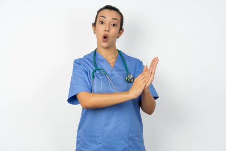Téléchargez les photos : Étonné femme arabe émotionnelle médecin en uniforme avec stéthoscope frotte les paumes et regarde la caméra avec incrédulité - en image libre de droit